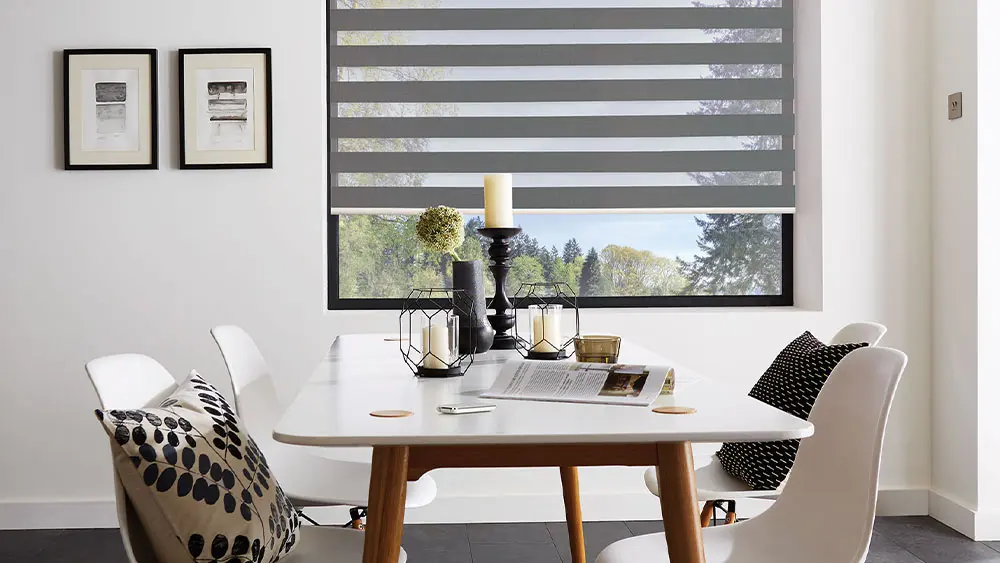 Dark grey vision blind with alternating sheer and opaque bands in a contemporary dining room